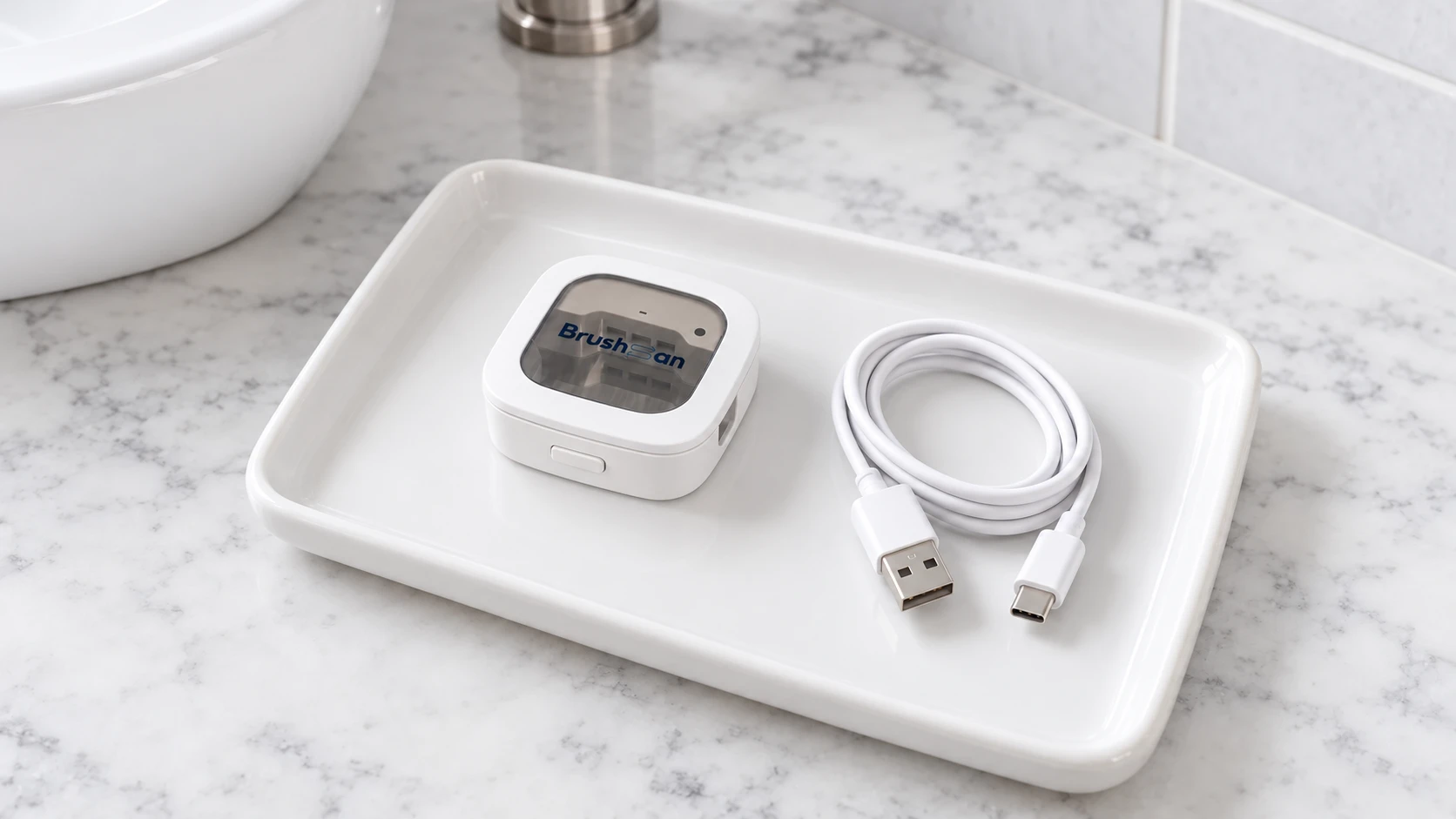 The BrushSan on a white ceramic tray beside its coiled white USB cable